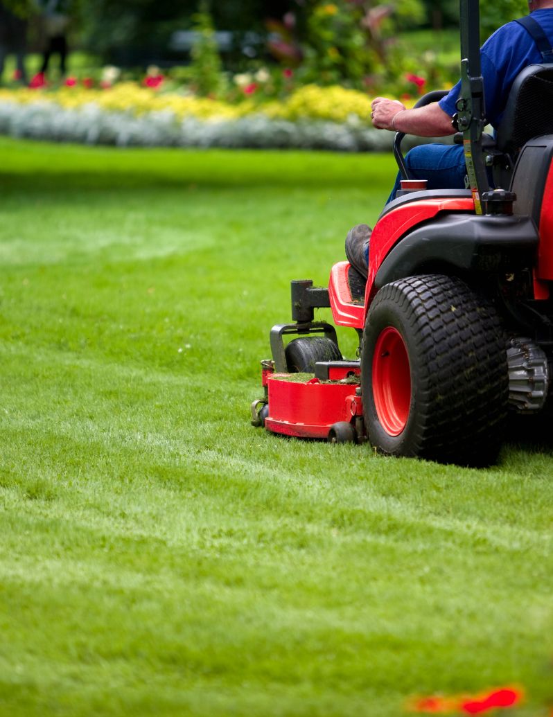Professional riding mower maintaining commercial property lawn